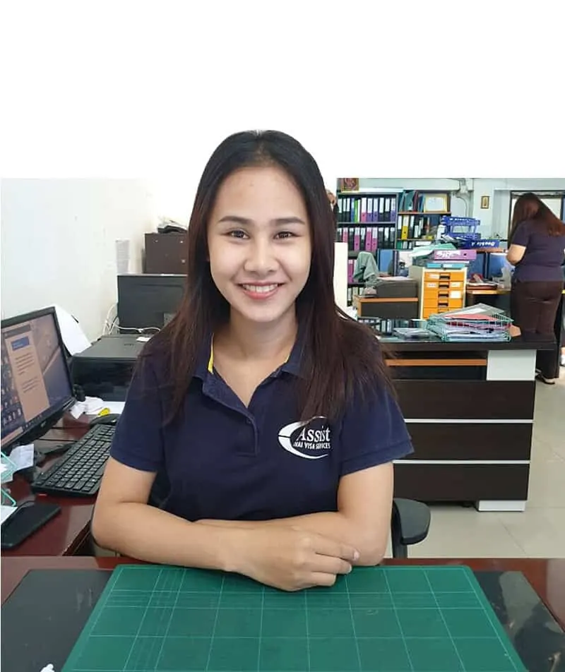 A smiling member of the Assist team at her desk